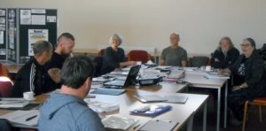A photograph of SPHP management team volunteers sitting around a table